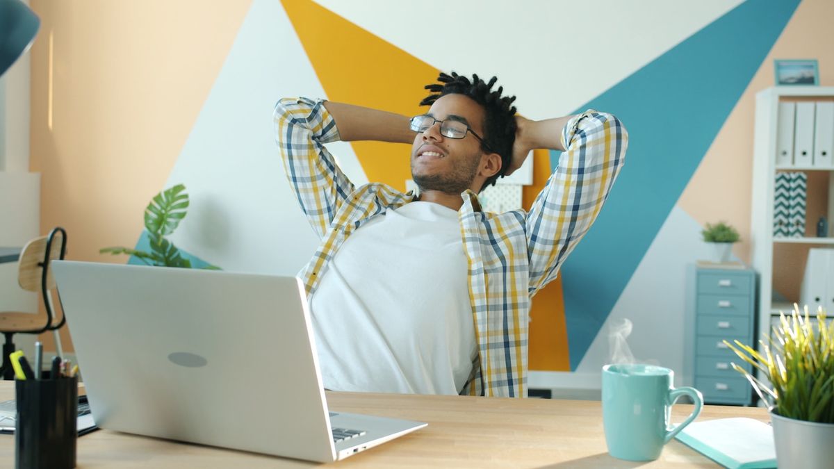 Person ved skrivebord med laptop og kaffe