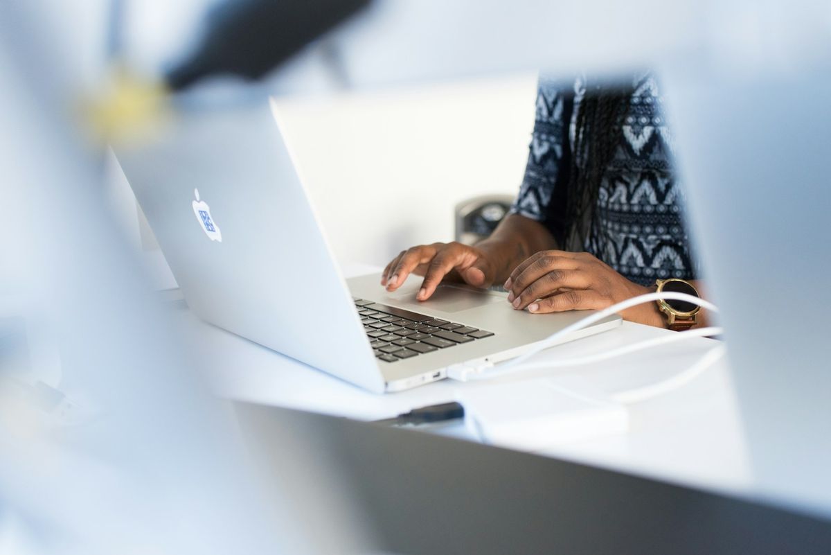 Person bruker laptop ved et skrivebord og soker informasjon