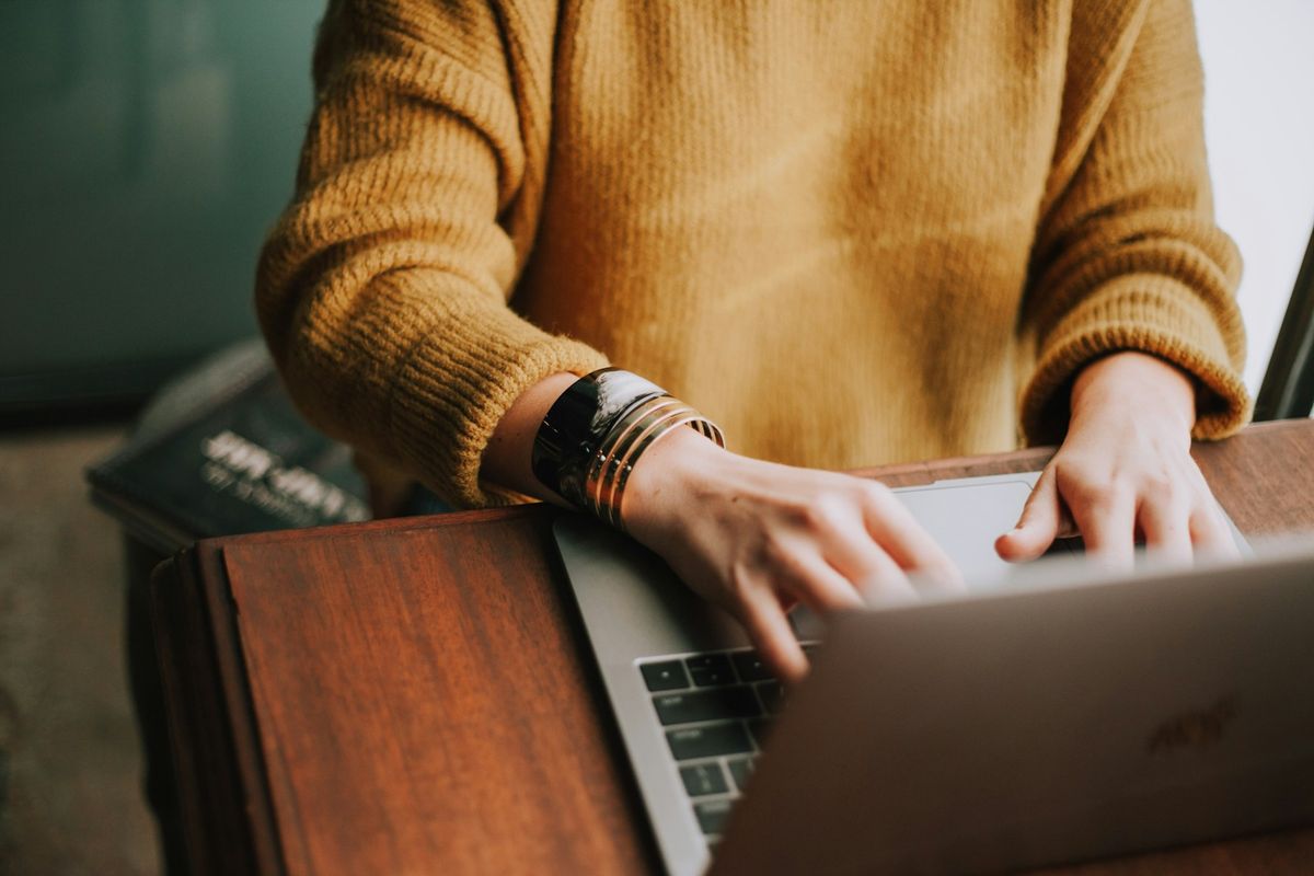 Person bruker laptop pa en rolig arbeidsplass