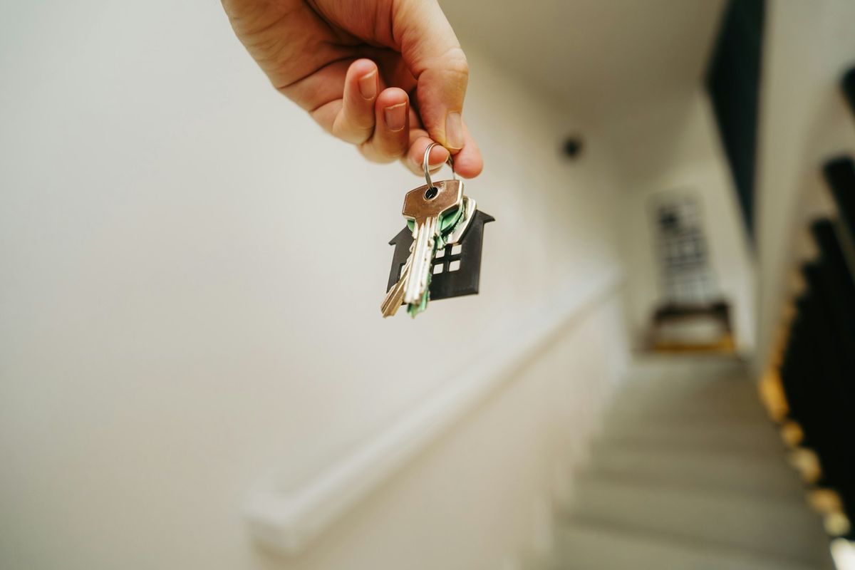 En person holder en husnokkel i handen
